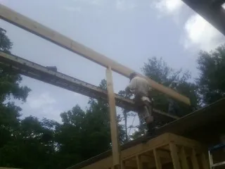 Carpenter setting a ridge beam over a new addition frame — Ice Dam Removal by Roofing Brothers in New Brighton