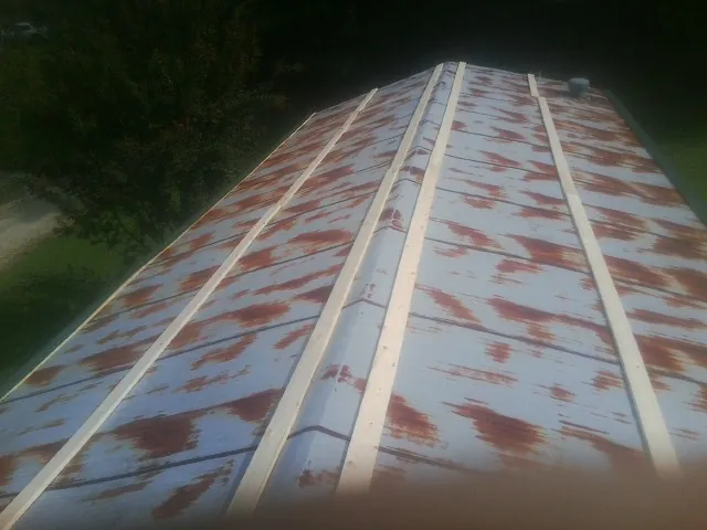Rusted metal roof panels with new wood purlins before replacement — Storm Damage Roof Repair in New Brighton by Roofing Brothers