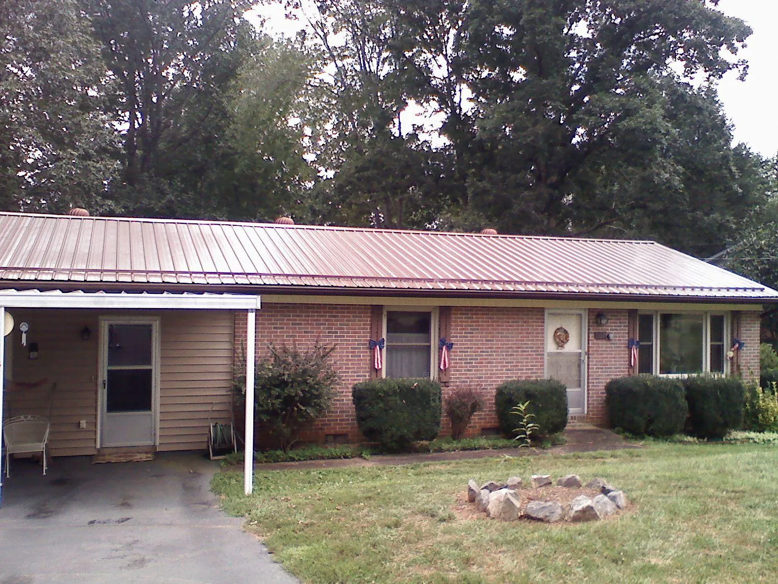 Bronze metal roof and carport on a brick ranch home — Roof Repair work by our crew in New Brighton